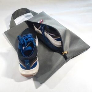 Sac à chaussures gris avec une chaussure posée dessus et une chaussure à l'intérieur