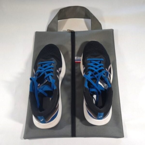 Sac à chaussures gris avec les deux chaussures posées dessus