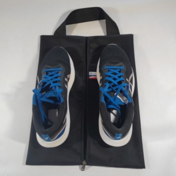 Sac à chaussures noir avec les deux chaussures posées dessus