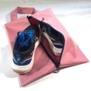 Sac à chaussures rose avec une chaussure posée dessus et une chaussure à l'intérieur