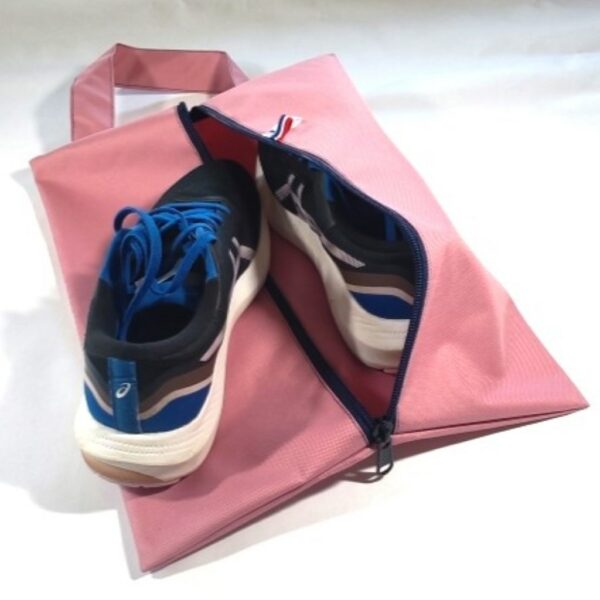 Sac à chaussures rose avec une chaussure posée dessus et une chaussure à l'intérieur
