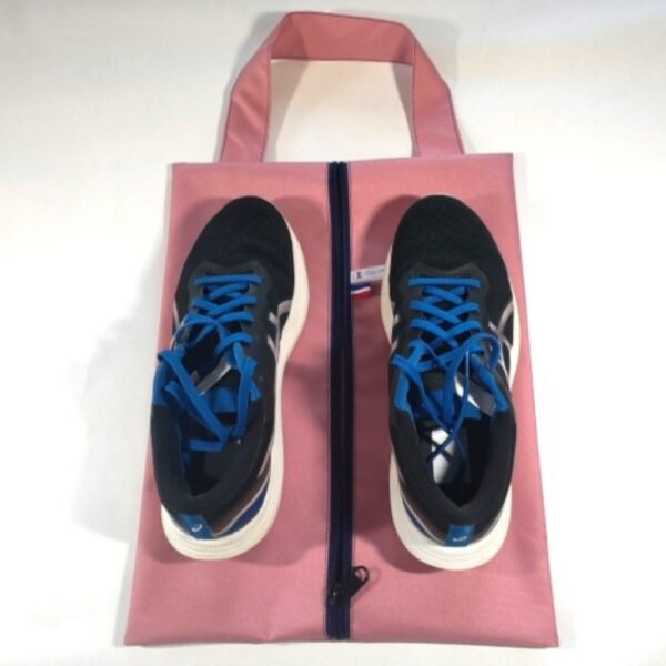Sac à chaussures rose avec les deux chaussures posées dessus