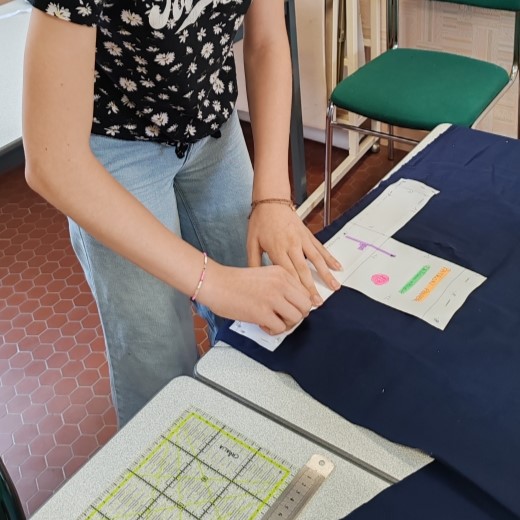 Une jeune personne en train d'épingler un patron sur du velour